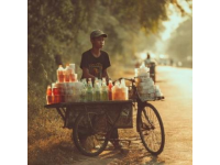 暑期的8月早上的三界鎮街頭吃包子，一輛賣西瓜的三輪車停在馬路邊，老伯正在稱西瓜。